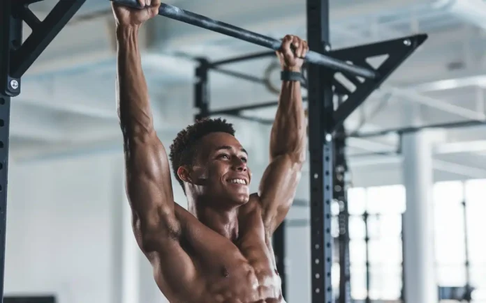 Person hanging from a pull-up bar demonstrating the benefits of hanging exercise