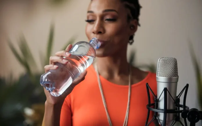 Vocal Health Tips: A singer drinking water to maintain vocal health