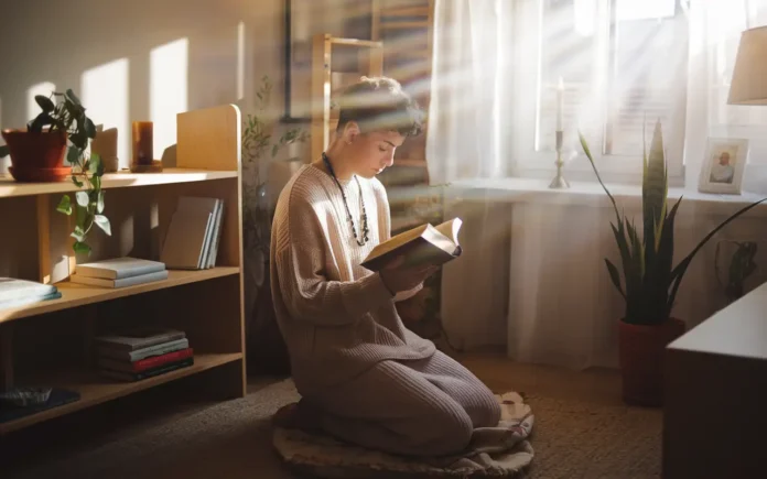 A serene setting of a person praying and fasting for breakthrough and deliverance, with sunlight streaming through a window.