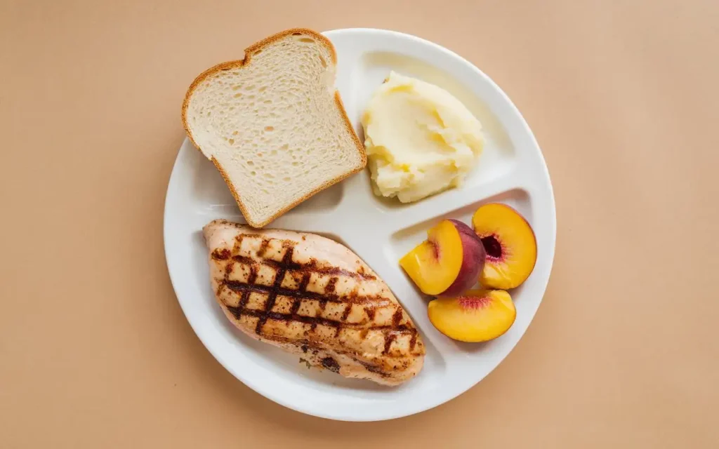 Low residue foods like boiled chicken and white bread on a plate