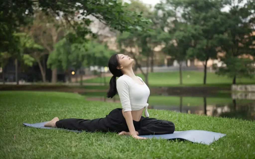 A woman performing yoga surrounded by nature to reduce stress and balance hormones.
