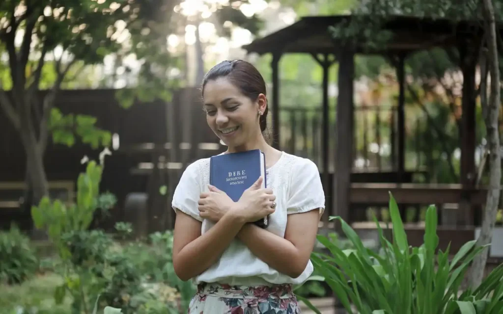 A smiling woman holding a Bible, symbolizing the impact of fasting prayer