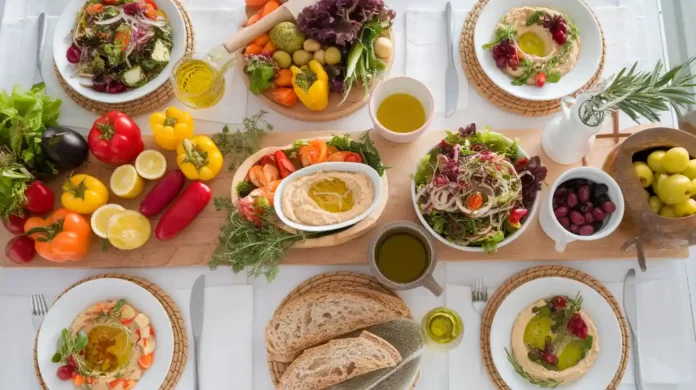 A colorful spread of Mediterranean vegetarian foods, including fresh vegetables, legumes, olive oil, and whole grains.