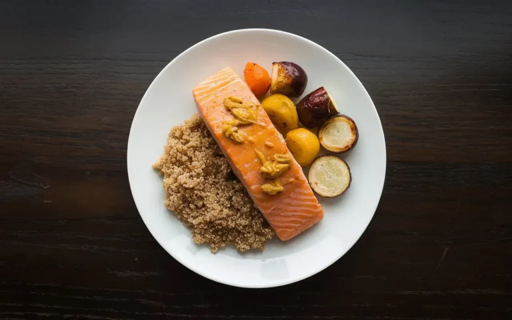 A beautifully arranged plate of mustard-glazed salmon with fresh vegetables, representing a mustard diet meal plan