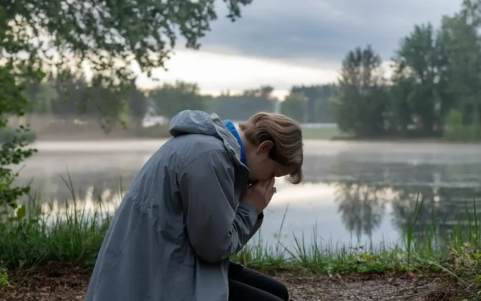 A person kneeling in prayer during fasting, reflecting in a serene environment.