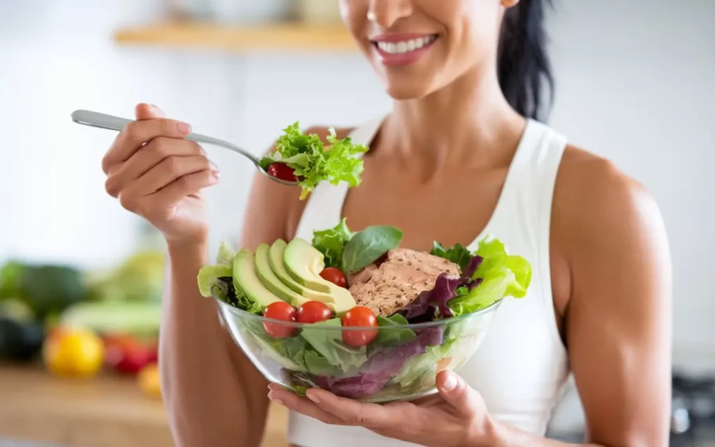 Woman holding a colorful bowl reflecting salad diet plan benefits